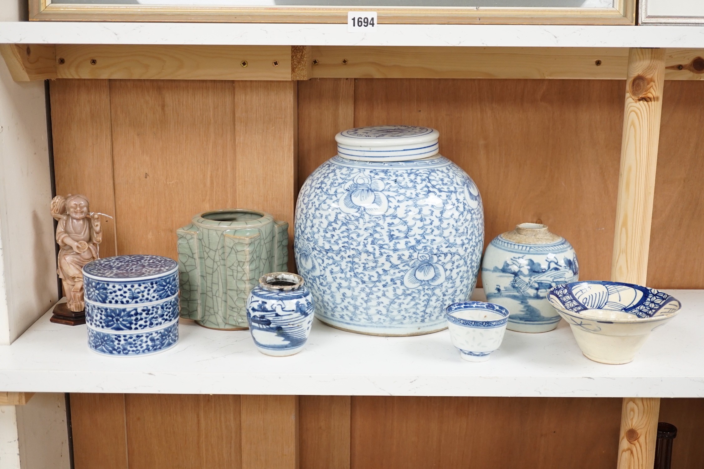 A group of 19th century blue and white jars, a stacking food box and two bowls, together with a celadon glazed cong vase and a soapstone figure of Liu Hai. Tallest 24cm